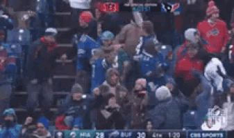 a crowd of people watching a football game with a player wearing a jersey with the number 13 on it