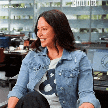 a woman wearing a denim jacket and a t-shirt with a letter b on it