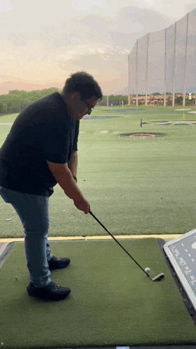 a man is swinging a golf club at a ball