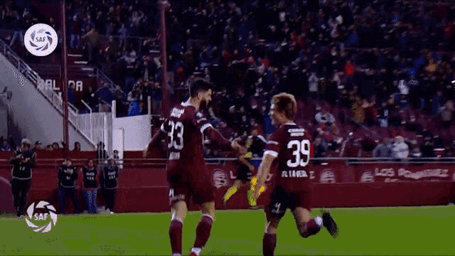 two soccer players wearing numbers 33 and 39 celebrate a goal