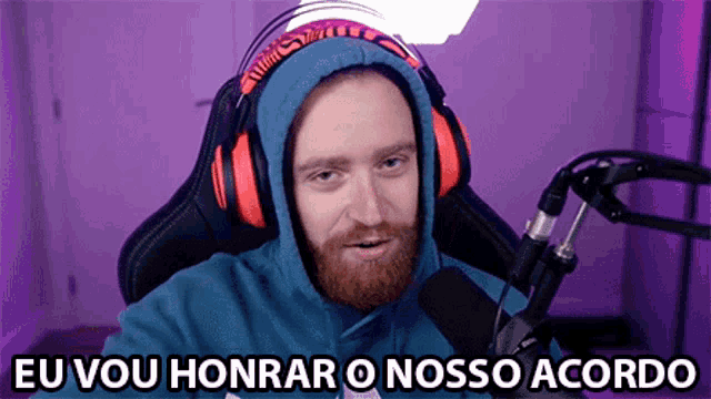 a man wearing headphones is sitting in front of a microphone and says eu vou honrar o nosso accordo