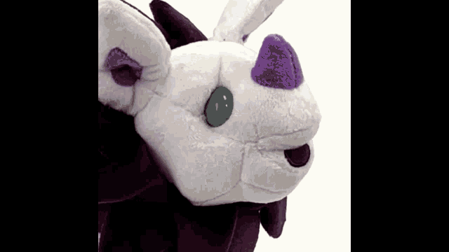 a close up of a stuffed animal with a green eye