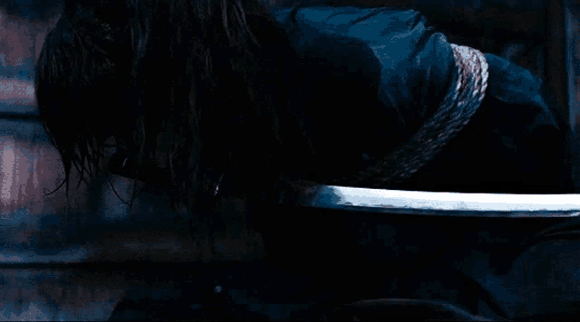a person with a rope around their neck holds a sword