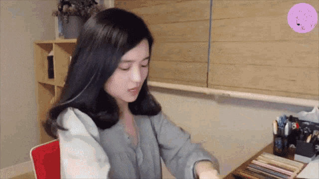 a woman sits at a desk with a purple sticker that says ' i love you ' on it