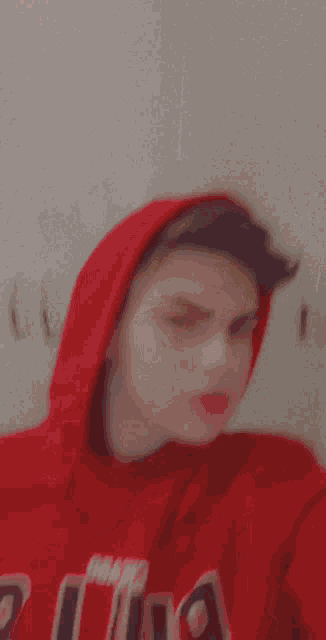 a young man wearing a red hoodie with the word chicago on it takes a selfie