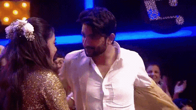 a man and a woman are dancing together in a dark room .