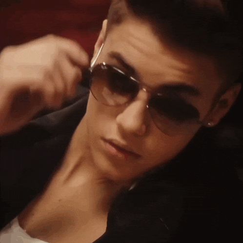 a close up of a person wearing sunglasses and a jacket