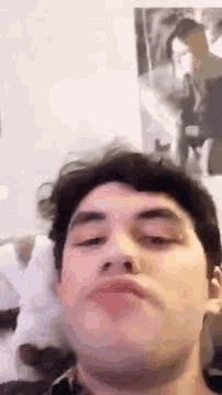 a young man is making a funny face with his eyes closed while wearing headphones .