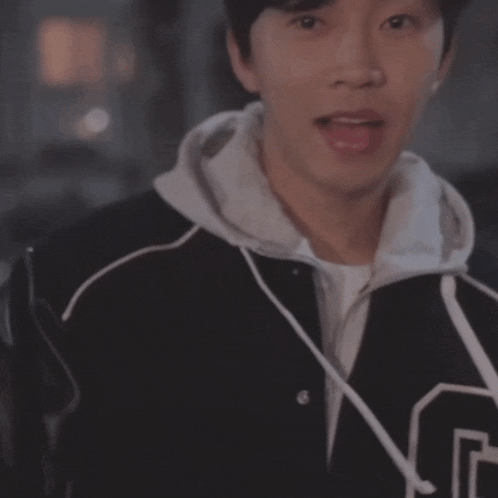 a man wearing a black jacket with a letter g on it