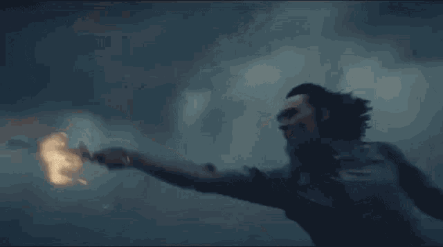 a man is flying through the air while holding a light in his hand .