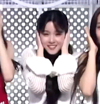 a woman is covering her ears with her hands while standing next to another woman .