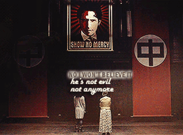 two women stand in front of a sign that says " show no mercy "