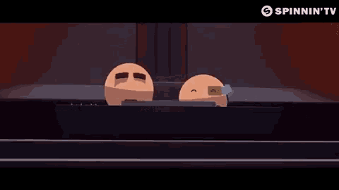 two cartoon balls are sitting next to each other on a table with a spinnin ' tv logo in the corner .