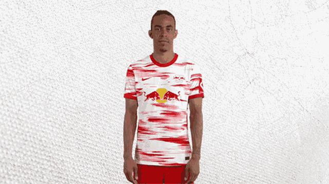 a man is wearing a red and white jersey with a red bull on it