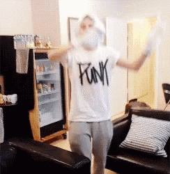 a man wearing a white shirt that says funk is dancing in a living room