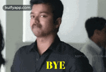 a man in a black shirt says bye in yellow letters .