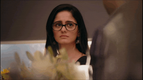a woman wearing glasses is looking at a man