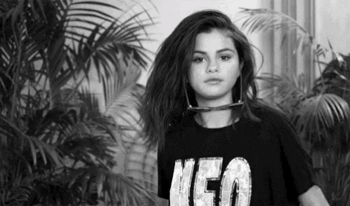 a black and white photo of a young woman wearing a black t-shirt with the word neo on it .