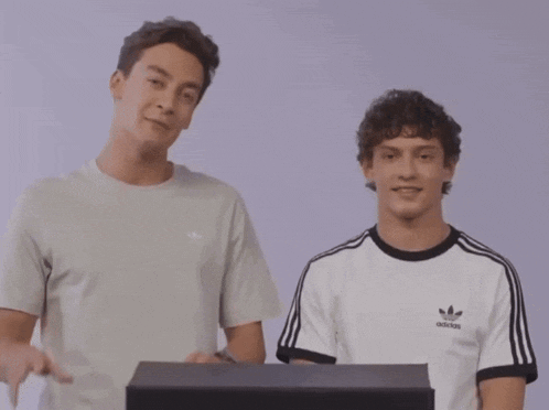 a man wearing an adidas t-shirt points to something