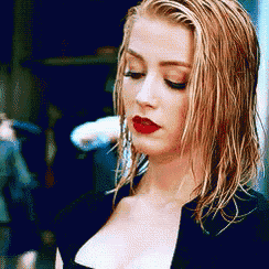 a close up of a woman 's face with wet hair and red lips
