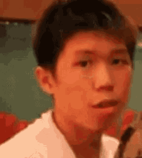 a close up of a young man making a funny face with his mouth open .