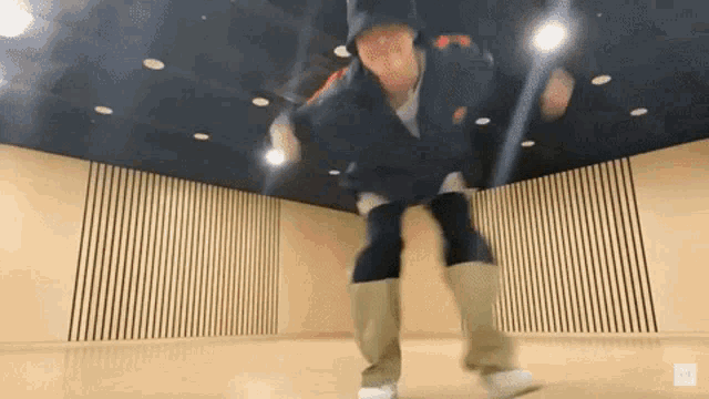 a person is jumping in the air in a dance studio