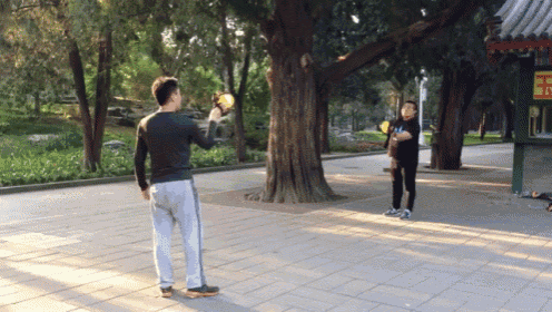 a man throws a frisbee in front of a sign that says ' 王 '