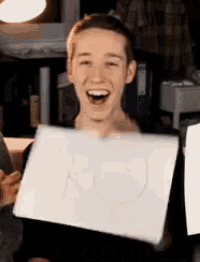a young man is holding up a piece of paper that says a on it