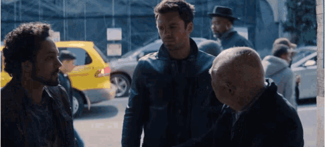 a group of men are standing in front of a taxi that says ' taxi ' on the back