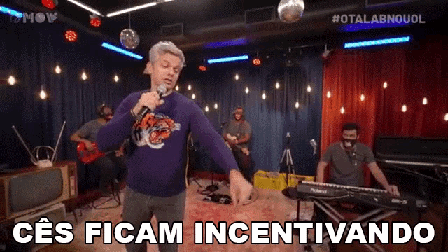a man singing into a microphone with the words " ces ficam incentivando " above him