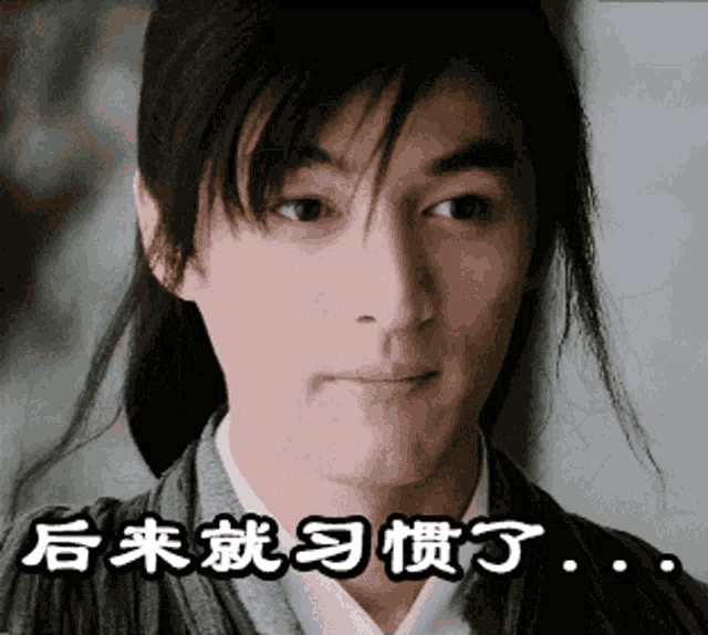 a close up of a man 's face with chinese writing behind him