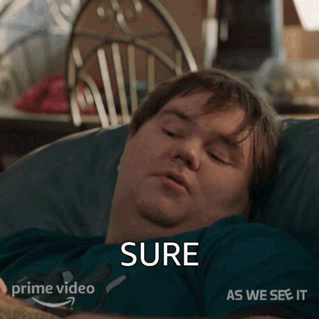 a man laying on a bed with the word sure written on his shirt