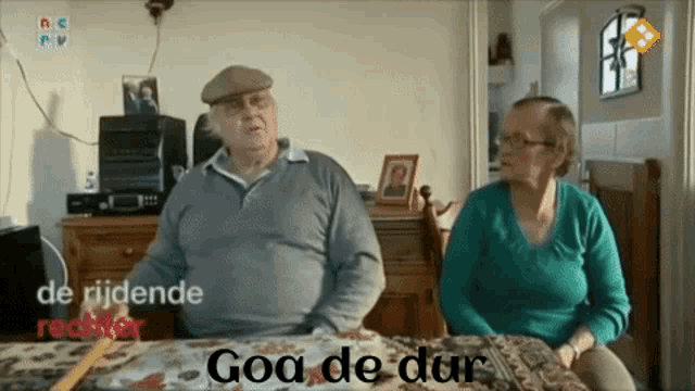a man and a woman are sitting at a table with the words goa de dur written above them