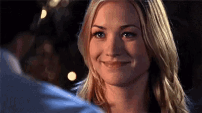 a woman is smiling at a man while looking at him .