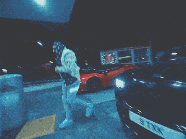 a blurred image of a person at a gas station with a red sign that says coca cola