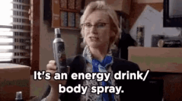 a woman is holding a bottle of body spray and says it 's an energy drink / body spray