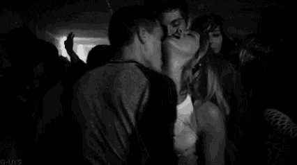 a man is kissing a woman in a crowd of people .
