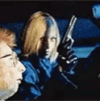 a man and a woman are in a car holding guns .