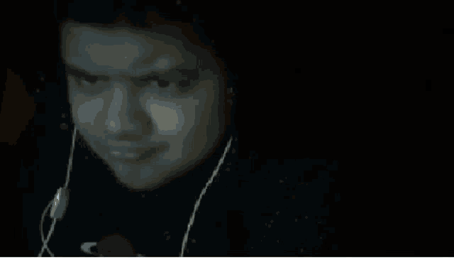 a man wearing headphones is making a funny face while looking at the camera .