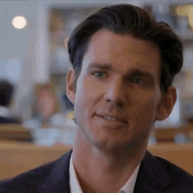 a man in a suit and white shirt is sitting at a table in a diner .
