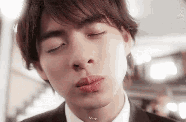 a close up of a man 's face with his eyes closed and his mouth open