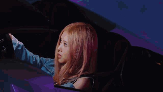 a close up of the side of a car with a pink light behind it