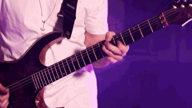 a man in a white shirt is playing a guitar with a strap that says ' fender ' on it