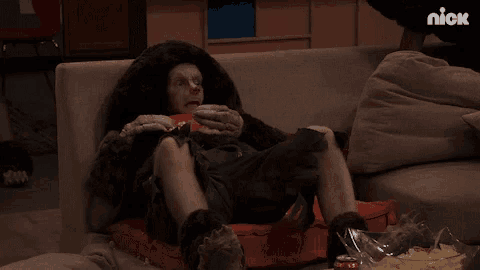 a man dressed as a gorilla is sitting on a couch with a bowl of chips