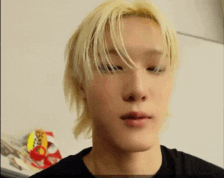 a young man with blonde hair is making a funny face .