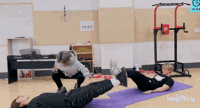 a man is doing exercises on a purple mat in front of a piano and a vlive sign