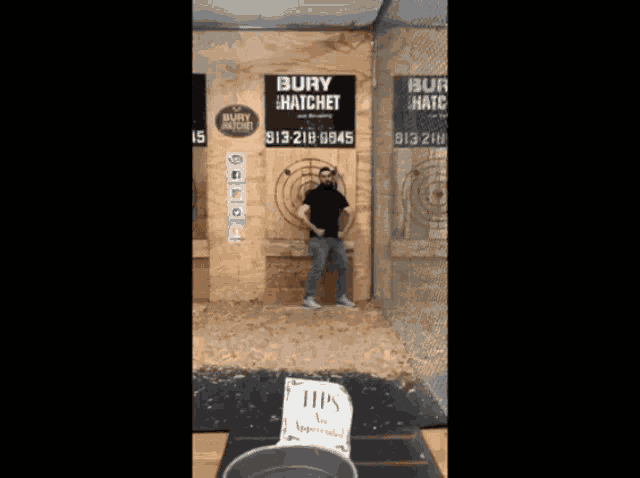 a man stands in front of a sign that says " bury hatchet "