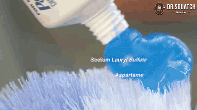 a bottle of sodium lauryl sulfate is being poured on a toothbrush