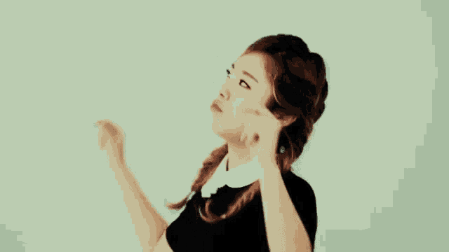 a woman in a black dress is dancing with her arms up in the air .