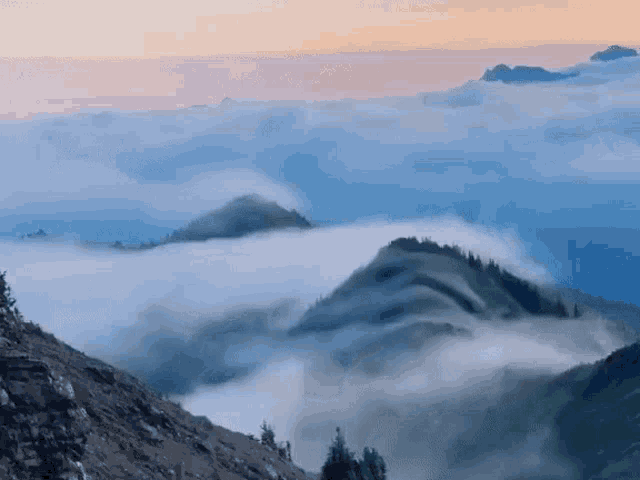a view of a mountain range covered in clouds